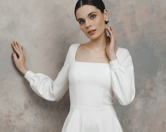 May include: A white, long-sleeved, square-neck wedding dress with a fitted bodice and a flowing skirt.