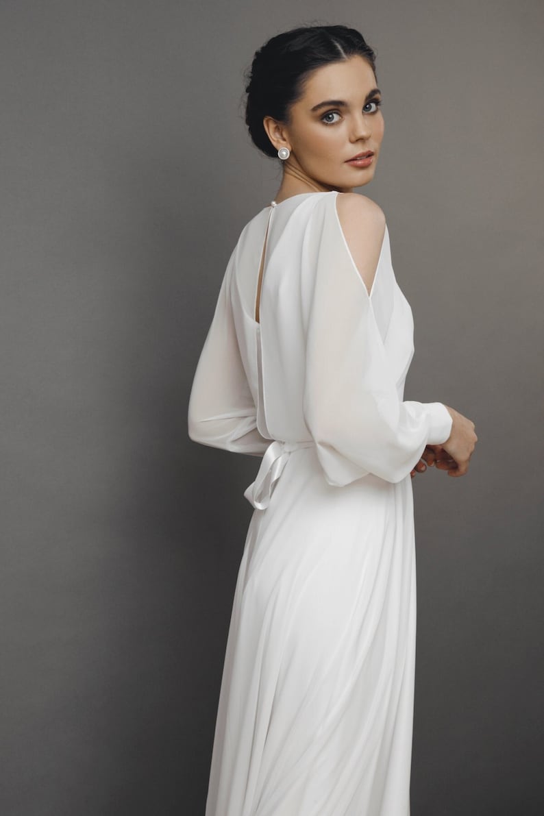 Simple chiffon wedding dress with sheer sleeves and flowing skirt for modern bride