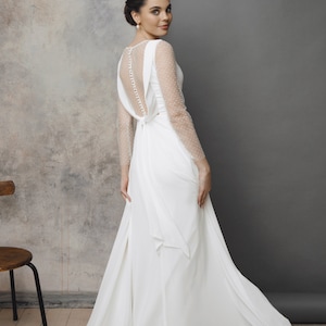 Simple and romantic wedding dress with sleeves.