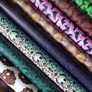 May include: A collection of patterned wrapping paper rolls, featuring designs like skulls, bats, and floral patterns. The rolls are arranged in a fan shape, showcasing the different designs.
