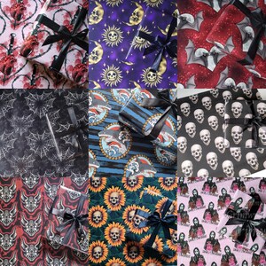 May include: Nine different designs of wrapping paper featuring various patterns, including skulls, bats, sharks, sunflowers, and a horror movie theme. The wrapping paper is decorated with black ribbon.