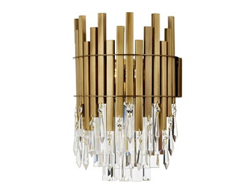 May include: A gold metal wall sconce with a geometric design and crystal accents. The sconce has a modern style and would be a great addition to any contemporary home.