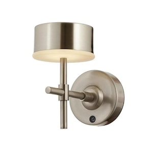 Könnte beinhalten: Eine Wandleuchte aus gebürstetem Nickel mit einem runden, zylindrischen Schirm und einem Schalter an der Basis.