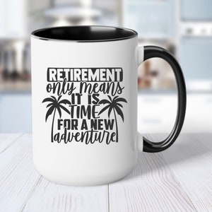 Könnte beinhalten: Weiße Kaffeetasse mit schwarzem Rand und Henkel. Die Tasse hat ein schwarzes Motiv mit der Aufschrift "Retirement only means it is time for a new adventure" mit Palmen auf beiden Seiten des Textes.