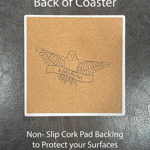 May include: Square coaster with a white border and a cork backing. The cork backing features a bird design with the text "KBKellyArt" on a banner. The text "Back of Coaster" is at the top, and "Non-Slip Cork Pad Backing to Protect your Surfaces" is at the bottom.