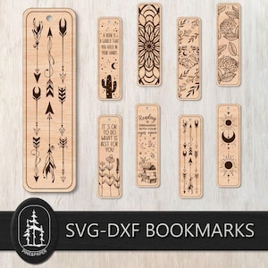 May include: A collection of laser-cut wooden bookmarks with various designs. Some bookmarks feature arrows, floral patterns, and celestial motifs. Others have inspirational quotes. The bookmarks are light brown with dark brown etched details.