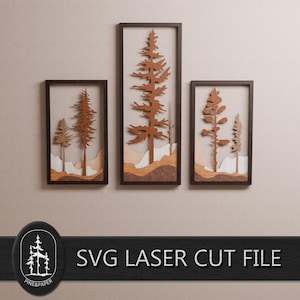 May include: Three framed wooden wall art pieces featuring laser-cut tree designs. The trees are various shades of brown and tan, set against a neutral background. The frames are dark brown. The text "SVG LASER CUT FILE" is visible.