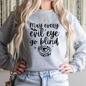 May include: A white ceramic mug with a black handle and the text "But first, coffee" in a black, handwritten-style font. The mug is on a white surface.