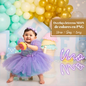 Puede incluir: Una niña pequeña con un vestido de tul morado sostiene un donut rosa y amarillo. Está sentada en una silla blanca frente a un fondo de globos pastel. El texto "Overlays letreros NEON de colores en PNG Uno - Dos - tres" es visible en la esquina superior derecha de la imagen. El texto "Uno Uno" es visible en la esquina inferior derecha de la imagen.
