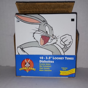 May include: A blue and yellow box of 10 blank 3.5 inch floppy disks featuring Bugs Bunny from Looney Tunes. The box says "Double Sided, IBM Formatted, High Density, Blank Diskettes, Volume One, Includes 5 Characters! See back for details."