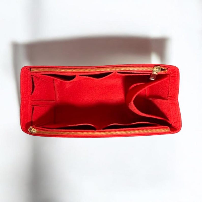Puede incluir: Organizador de bolso de fieltro rojo con m&uacute;ltiples compartimentos y cierre de cremallera. El organizador tiene una cremallera dorada y est&aacute; dise&ntilde;ado para caber dentro de un bolso m&aacute;s grande.