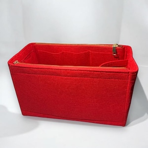 Puede incluir: Organizador de bolso de fieltro rojo con m&uacute;ltiples compartimentos y cierre de cremallera.
