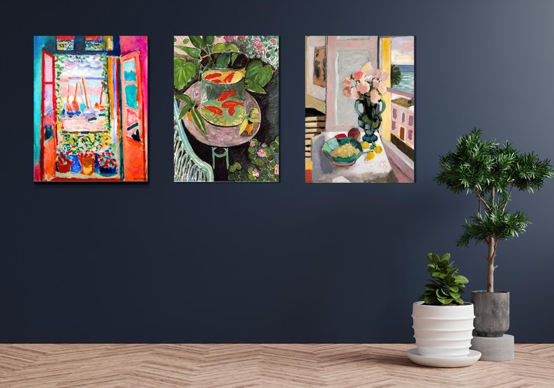 May include: Three paintings in colorful, impressionistic styles. The leftmost painting shows a window with an open view of a beach and sailboats. The middle painting shows a bowl of goldfish on a table with green plants. The rightmost painting shows a vase of pink flowers on a table with a view of a beach and a palm tree.