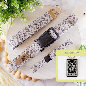 May include: A set of dog accessories, including a collar, leash, and keychain tag. The items feature a cream-colored fabric with a black celestial pattern. The keychain tag displays a black and white image of the moon.