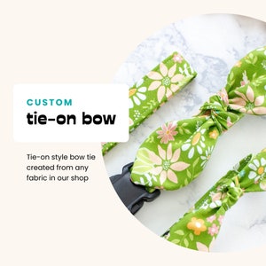 May include: A custom tie-on bow in a floral pattern with green, pink, and white flowers. The bow tie is made from fabric and features a black buckle. The text "CUSTOM tie-on bow" is displayed on the image.
