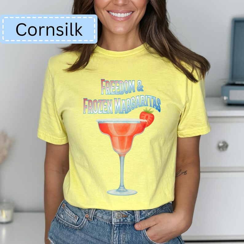 May include: Yellow t-shirt with the text "Freedom & Frozen Margaritas" and a margarita glass graphic. The shirt also has the word "Cornsilk" in a light blue box.