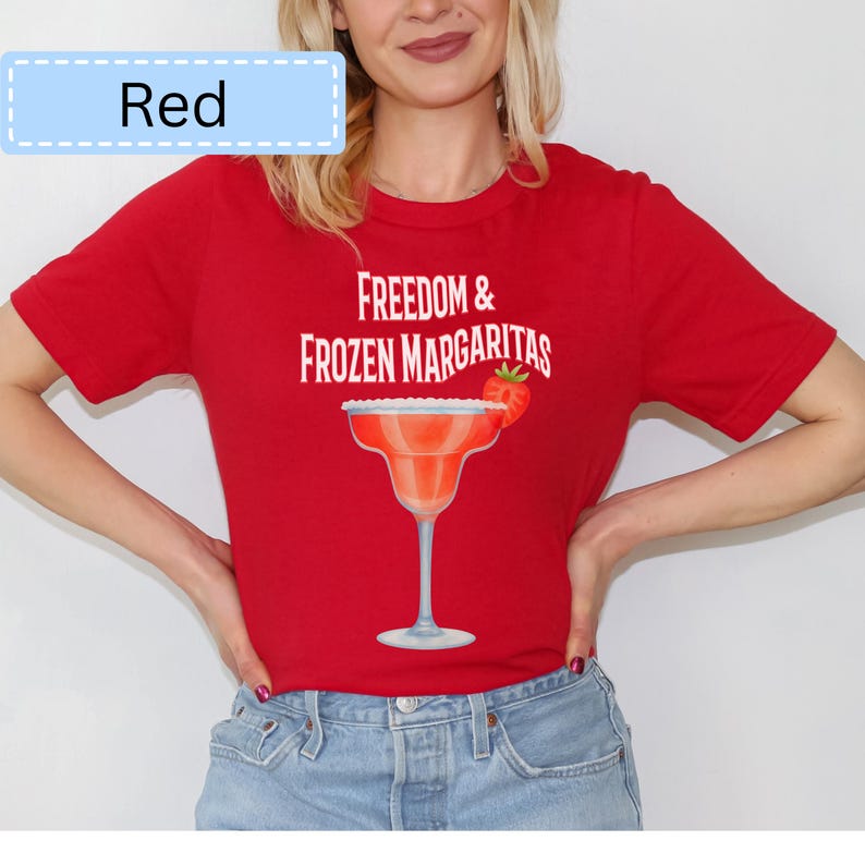 May include: Red t-shirt with the text "Freedom & Frozen Margaritas" and a margarita glass graphic. The margarita glass has a strawberry garnish. The word "Red" is in a light blue box in the upper left corner.