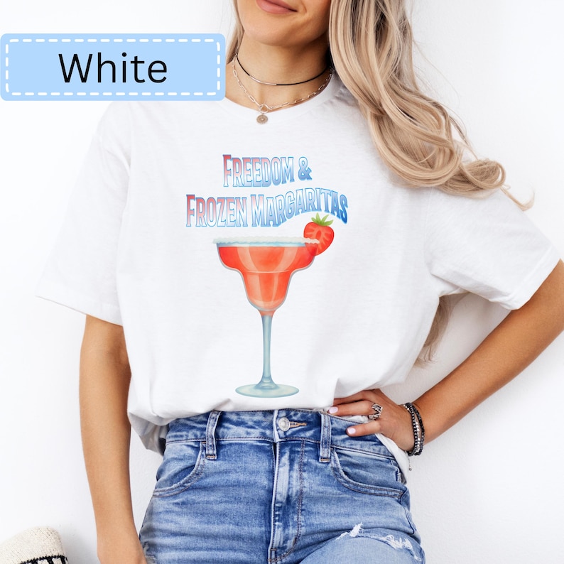 May include: White t-shirt with a graphic of a margarita cocktail and the text "Freedom & Frozen Margaritas". The margarita is red with a strawberry garnish. The word "White" is in a light blue box at the top left.