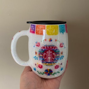 May include: White glitter tumbler with a black lid and a colorful Mexican-inspired design featuring a Starbucks logo with the text "F&Eacute;CITO" and "ORIGINS".
