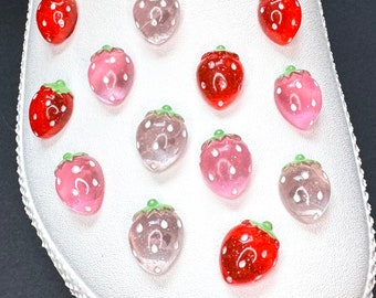 May include: White clog shoe with 13 strawberry charms. The charms are red, pink, and clear with white dots. The charms are arranged in a random pattern on the shoe.