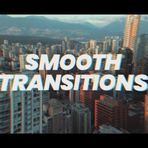 May include: An aerial view of a cityscape with the words "SMOOTH TRANSITIONS" in white, outlined in blue. The buildings are various shades of brown and gray, with mountains in the background.