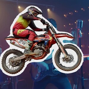 Puede incluir: Una moto de motocross roja y blanca con un piloto con un traje de carreras rojo, amarillo y negro. La moto está en el aire, con el piloto inclinándose en una curva. El fondo es una imagen borrosa de una banda tocando en un escenario.