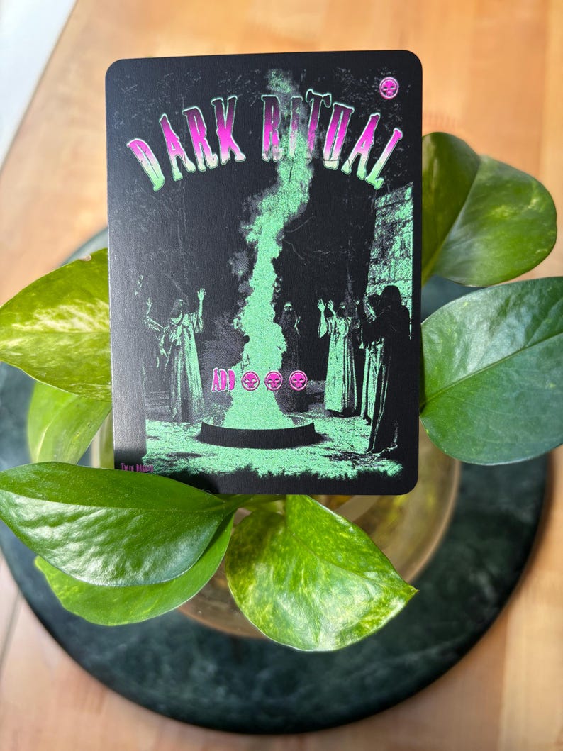 Pode incluir: Um cart&atilde;o preto com as palavras "DARK RITUAL" em rosa e verde. O cart&atilde;o apresenta uma chama verde e figuras em vestes. O cart&atilde;o &eacute; cercado por folhas verdes.