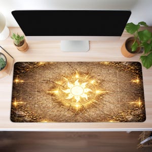 May include: A rectangular desk mat with a detailed, textured brown surface. The mat features a glowing golden sunburst design in the center, with radiating lines and accents. The design is set against a cracked, stone-like background.