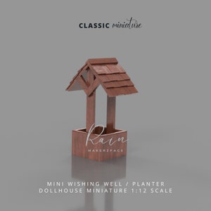 Peut inclure: Un petit puits en bois miniature avec un toit en bardeaux. Le pot est peint en brun et porte l'inscription "Rain Makerzpace" sur le devant.