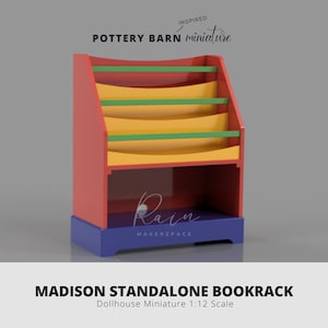 May include: A miniature, colorful Madison Standalone Bookrack. The dollhouse-sized bookcase features a red frame, blue base, and yellow shelves with green and red accents. The text "Pottery Barn miniature" and "Rain Makerzpace" are visible.