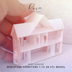 May include: A white, three-story dollhouse model with open interior spaces and window cutouts. The miniature house is held in a hand, with the text "Rain Maker Space" and "DOLLHOUSE MINIATURE FURNITURE 1:12 3D STL MODEL" visible.