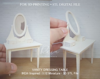 Könnte beinhalten: Weißer Schminktisch mit Spiegel und zwei Schubladen. Der Tisch ist ein 1:12 Miniaturmodell und für den 3D-Druck konzipiert. Der Text "FOR 3D PRINTING STL DIGITAL FILE" und "VANITY DRESSING TABLE IKEA-Inspired 1:12 Miniature 3D STL File" ist im Bild sichtbar.