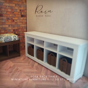 May include: A white sofa back table with eight cubby holes, each containing a brown basket. The table is part of a miniature furniture set. The text "Rain MAKER PACE" is above the table. The text "SOFA BACK TABLE MINIATURE FURNITURE 1:12 3D STL MODEL" is below the table.