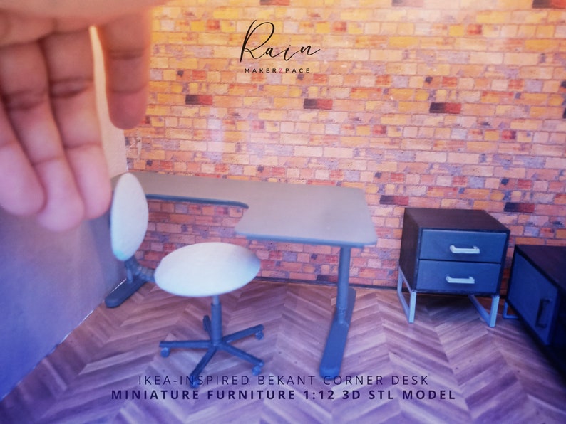 K&ouml;nnte beinhalten: Ein grauer Miniatur-Ecktisch mit einem wei&szlig;en Stuhl und einem grauen Nachttisch mit zwei Schubladen. Der Schreibtisch ist mit "IKEA-INSPIRED BEKANT CORNER DESK MINIATURE FURNITURE 1:12 3D STL MODEL" beschriftet.