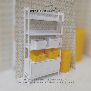 Pode incluir: Estante branca com quatro prateleiras e uma gaveta. A estante &eacute; decorada com quatro caixas de armazenamento brancas e duas caixas de armazenamento amarelas. O texto "INSPIRED WEST ELM miniature" est&aacute; no topo da estante. O texto "MID-CENTURY BOOKSHELF DOLLHOUSE MINIATURE 1:12 SCALE" est&aacute; na parte inferior da imagem.