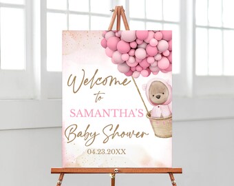 May include: A rectangular welcome sign for a baby shower featuring a watercolor teddy bear in a basket attached to a cluster of pink balloons. The text reads Welcome to SAMANTHA'S Baby Shower 04.23.20XX in gold and pink script and block lettering.