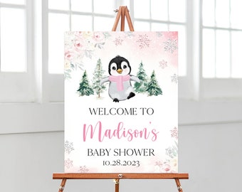 May include: Welcome to Madison's Baby Shower sign with a pink and white penguin illustration, pink floral accents, and snowflakes on a pink background.