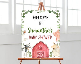 May include: Welcome to Samantha's Baby Shower sign with a red barn, a cow, a sheep, a goose, and a pig. The sign is decorated with green leaves.