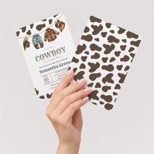 May include: A baby shower invitation card featuring a clothesline with a brown hat, blue jeans, a brown jacket, and brown boots. The text reads A LITTLE COWBOY IS ON HIS WAY! honoring Samantha Green on Friday 25 October. The back has a brown cow print.