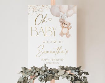 May include: A white welcome sign with gold lettering that says "Oh Baby" and "Welcome to Samantha's Baby Shower 07.09.20XX". A teddy bear with a bow is holding balloons in the top left corner.