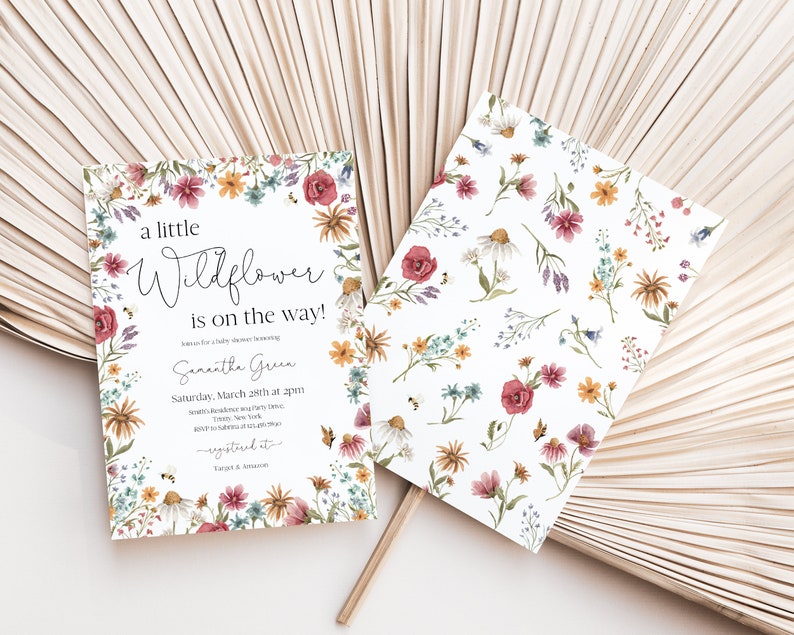 May include: A white baby shower invitation with a floral border. The text reads "a little Wildflower is on the way!" and includes the name "Samantha Green" and the date and time of the shower.