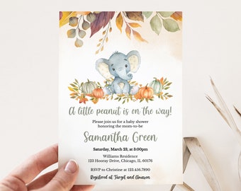 Puede incluir: Invitación a un baby shower con una ilustración en acuarela de un elefante gris, calabazas y hojas de otoño. El texto dice "A little peanut is on the way!" e incluye los detalles del evento.