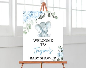 May include: A blue and white baby shower welcome sign featuring a watercolour illustration of an elephant and blue roses. The sign reads "Welcome to Jayme's Baby Shower".