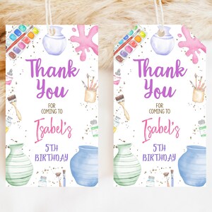 May include: Two white thank you tags with purple text. The tags feature a watercolor illustration of paintbrushes, paint tubes, and pottery. The text reads "Thank You for coming to Isabel's 5th Birthday."