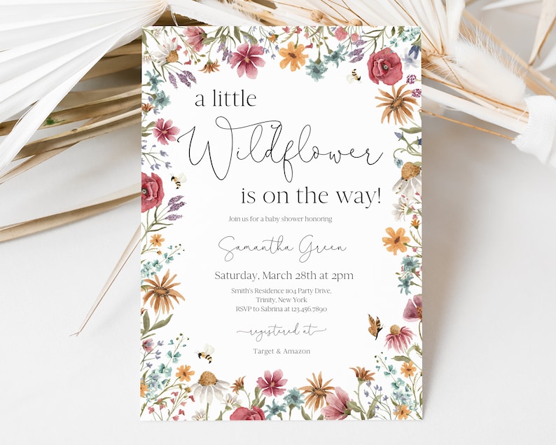 May include: A white baby shower invitation with a floral border. The text reads "a little Wildflower is on the way!" Join us for a baby shower honouring Samantha Green. Saturday, March 28th at 2pm. Smith's Residence at Party Drive, Trinity, New York. RSVP to Sabrina at 123.456.7890. Registered at Target & Amazon.
