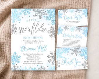 May include: A baby shower invitation set featuring light blue and silver snowflake illustrations. The main card reads A LITTLE SNOWFLAKE IS ON THE WAY, honoring Brianne Hill. Includes matching Diaper Raffle, Books for Baby, and Thank You cards.