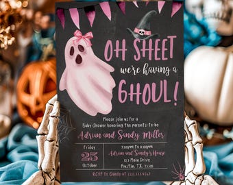May include: A Halloween-themed baby shower invitation with a black background. The invitation features a pink ghost with a bow, a witch hat, and the text "OH SHEET we're having a GHOUL!" Details include the date, time, and location.