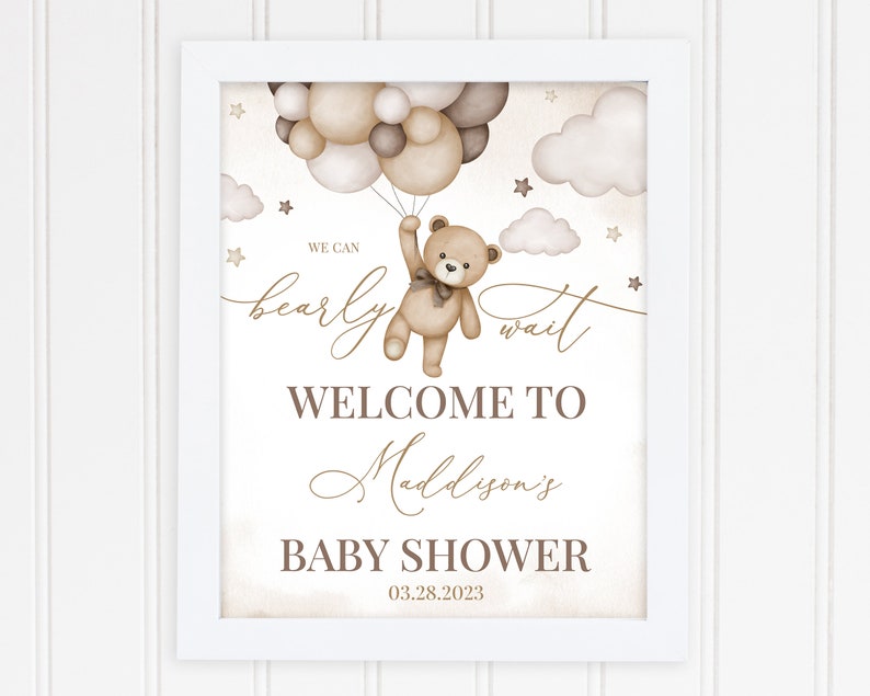 K&ouml;nnte beinhalten: Ein brauner Teddyb&auml;r, der Ballons h&auml;lt, mit dem Text "We can bearly wait" und "Welcome to Madison's Baby Shower 03.28.2023".