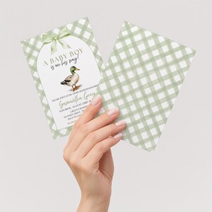 Peut inclure: Deux cartes d'invitation rectangulaires pour une f&ecirc;te pr&eacute;natale avec un motif vichy vert sauge et blanc. Une carte pr&eacute;sente une illustration &agrave; l'aquarelle d'un canard colvert, un n&oelig;ud vert et le texte A BABY BOY is on his way! pour Samantha Green.