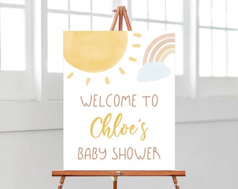 May include: Welcome to Chloe's Baby Shower sign with a watercolor illustration of a sun, rainbow, and cloud.